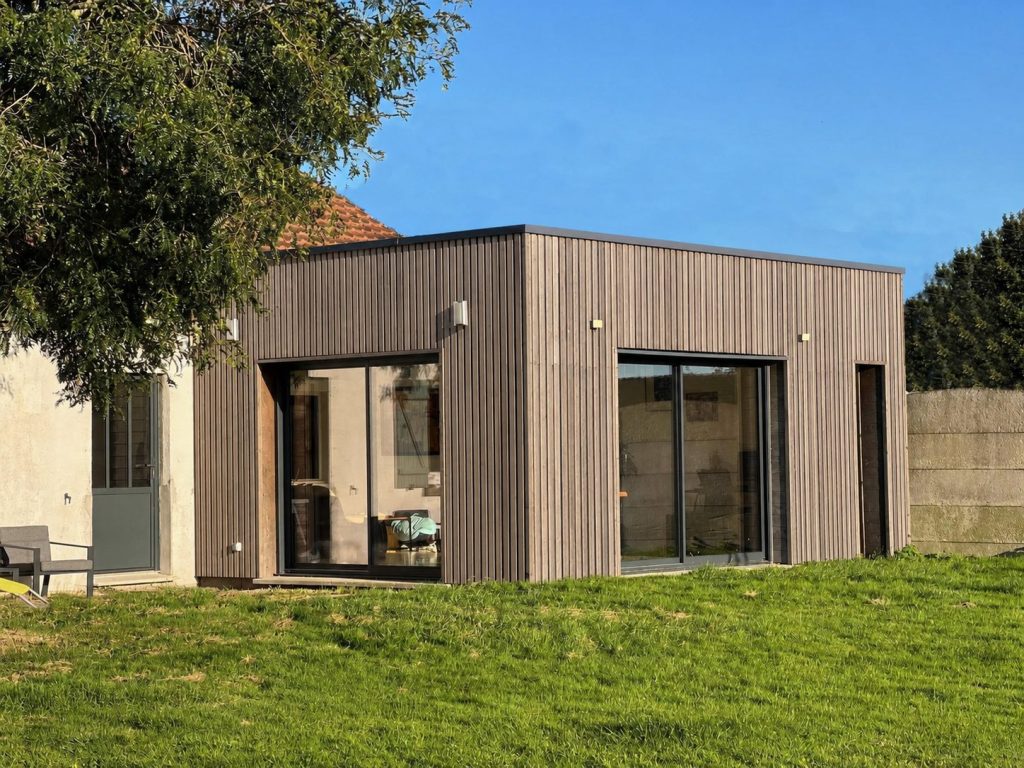 Extension bois à ossature avec bardage vertical et grandes baies vitrées, réalisée par Autrement Bois en Pévèle