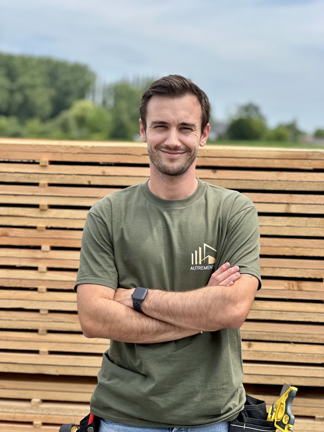 Thomas Galand, artisan constructeur bois et fondateur d'Autrement Bois, devant un stock de bardage en Pévèle